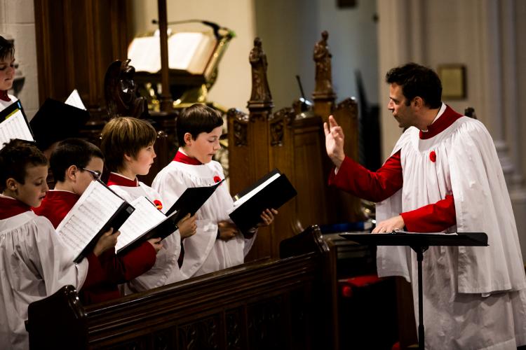 Director conducting four boy choristers during a church service